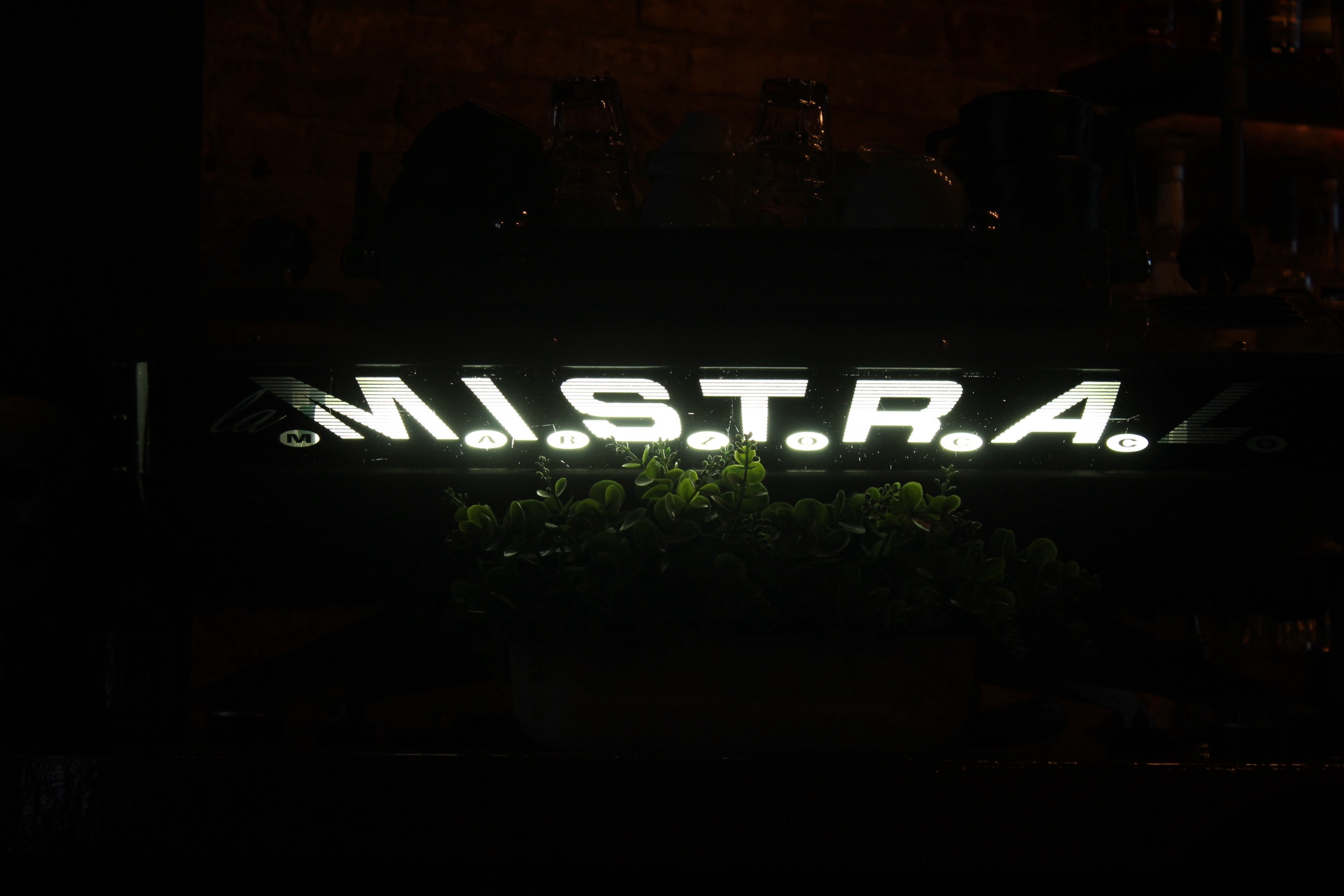 Aura's espresso machine with coffee cups stacked above it
